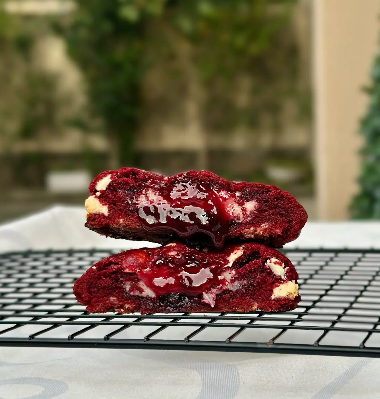 Cookie red velvet cortado ao meio, mostrando o recheio de geleia artesanal